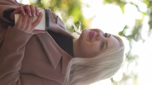Young Woman Smiling Holding Paper Cup Outside