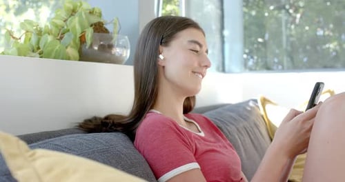 Young Woman Relaxing on Couch with Mobile Device
