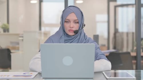 Arab Woman with Headset in Call Center Working on Laptop