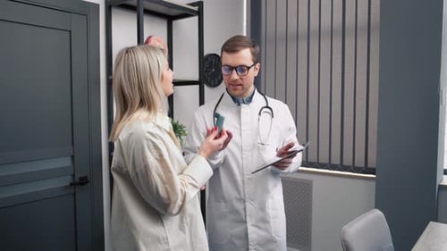 Consultation of the ENT doctor with the patient. Male doctor with an inhaler for asthmatics