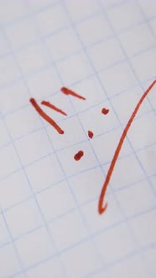 Man Writes Exclamation Marks with Red Marker on Paper Macro
