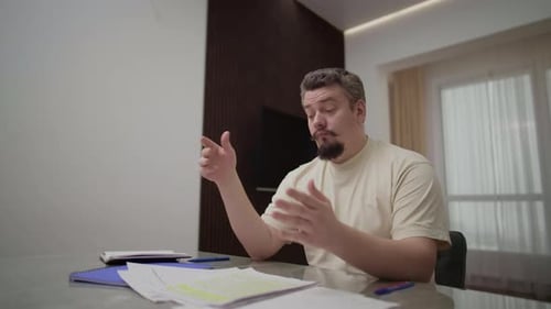 Stressed Man Throws Documents Feeling Overwhelmed at Home Office