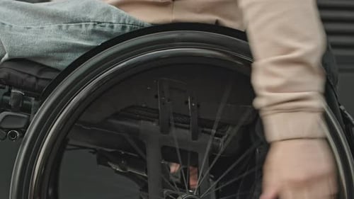 Person Propelling Wheelchair Forward in Urban Environment