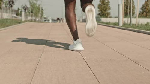 Legs of Black Man Jogging on City Street