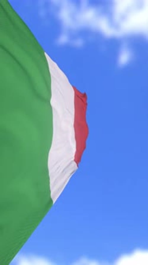 Drapeau italien flottant dans le vent contre un ciel bleu vif
