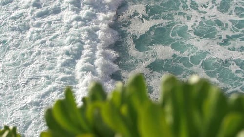 Slow motion view of tropical ocean waves crashing, swirling and foaming. Aerial top down.