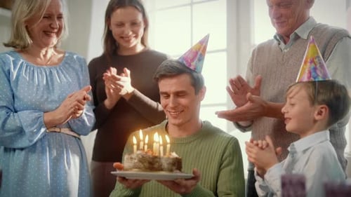 Family Celebrates Birthday Together with Cake and Candles