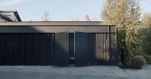 Front View on Black Car Leave Modern Garage with Automatic Open Gate