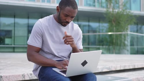 African American Man Freelancer Using Laptop Typing Chatting on Urban Street in City Guy Having