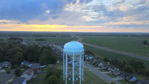 Pushing backwards drone shot of the watertower in Clarksville revealing downtown Clarksville
