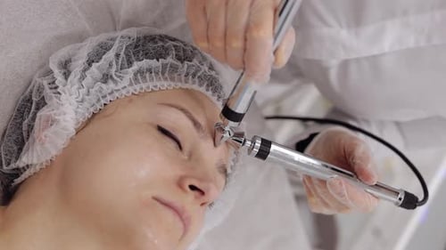 Woman Receiving Facial Treatment at Clinic