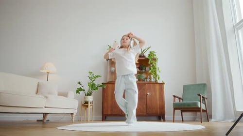 Happy Child Dancing with Headphones in Living Room