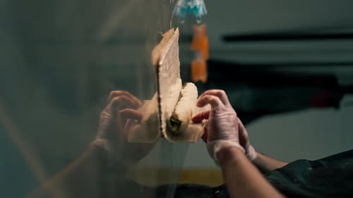 Vertikale Video-Nahaufnahme in einer professionellen Küche auf dem Tisch Ein Koch in Handschuhen sammelt Sushi-Rollen