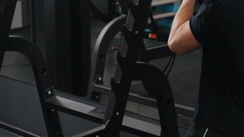 Man Adding Weight to Barbell in Gym