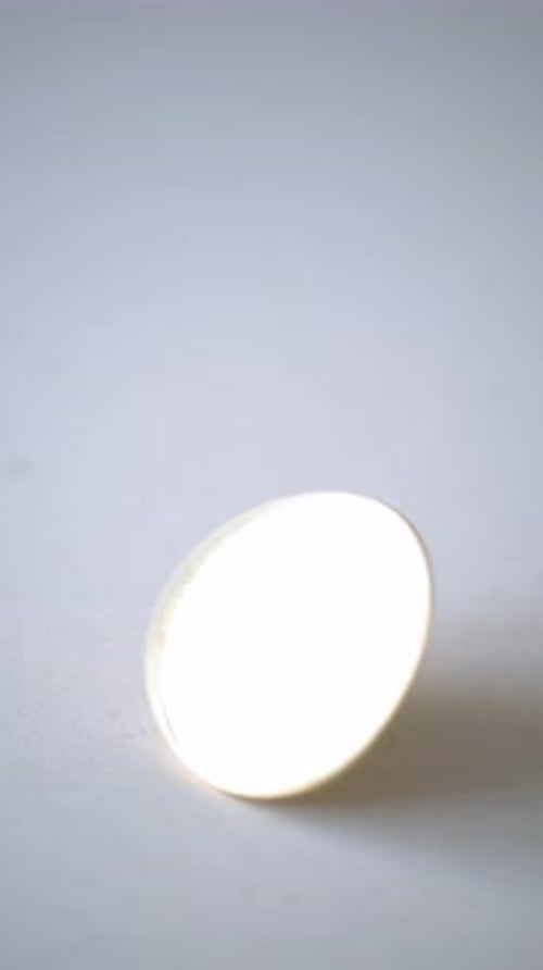 Gold Bitcoin Spinning on White Surface