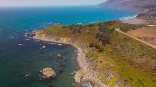 Rocky beach covered with moss, lichen and few bushes. Amazing coastline of Pacific at Morro Bay