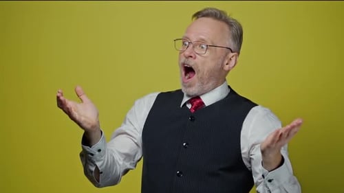 Expressive Man with Gray Hair Reacting on Yellow Background