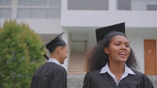 African American student celebrating college achievement outside campus.