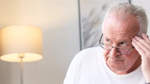 Senior Man Thinking With Fingers On Forehead