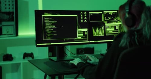 Person Typing on Keyboard in Dark Room