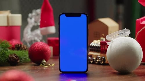 Phone with Blue Screen Amidst Christmas Decorations