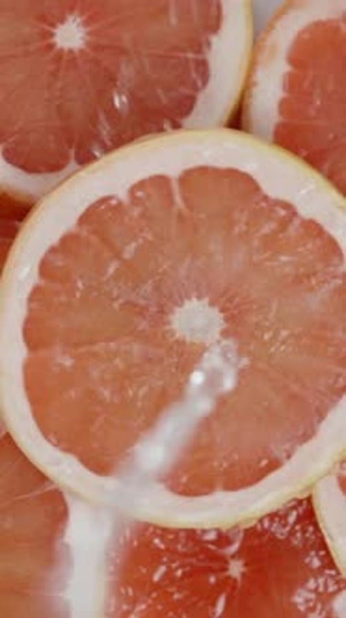 Splashing Water on Fresh Grapefruit Slices