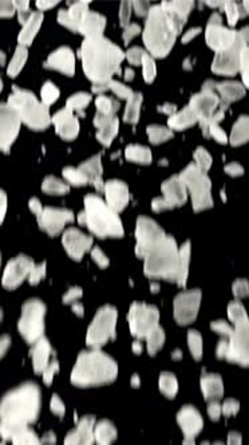Falling Salt Crystals on a Black Background Filmed on a Highspeed Camera at 1000 Fps