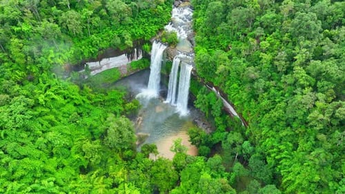 Aerial view over a waterfall in a beautiful tropical forest.