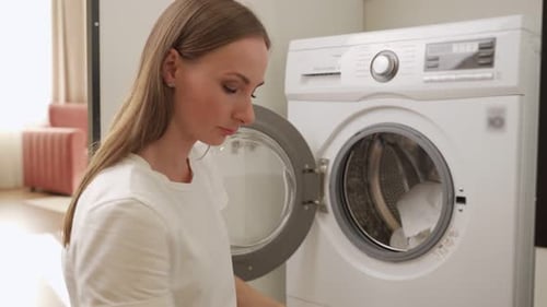 Woman Loading Laundry into Washing Machine at Home