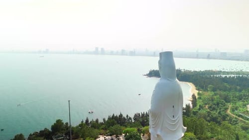 Towering White Buddha Statue Overlooking Da Nang Cityscape Coastline and Ocean Embodying Spiritual