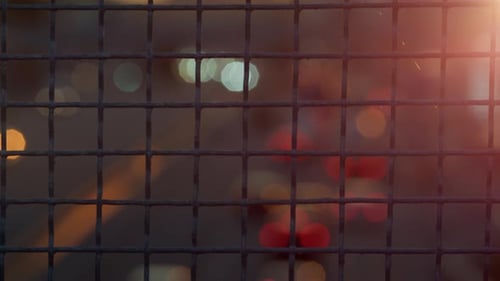 Closeup Metallic Squared Netting Fence In Golden Sunlight. Big City Life Concept. Blurred Beautif...