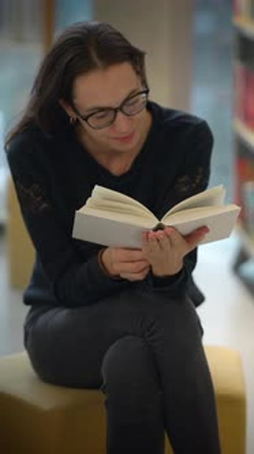 A Joyful Reader Delightfully Enjoying a Book While Seated Comfortably in a Cozy Library