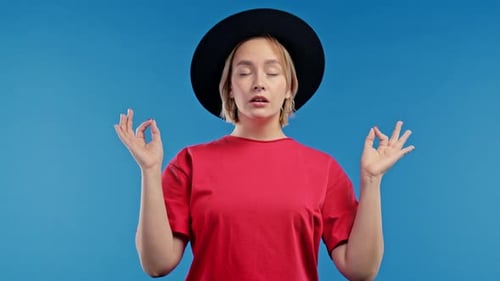 Woman Meditating Calmly Against a Blue Background