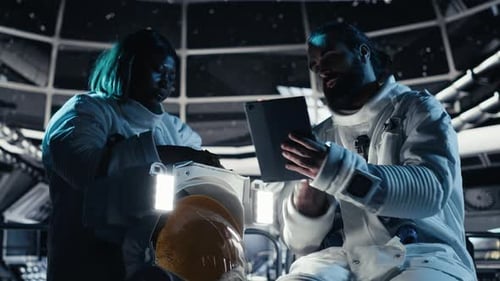 Astronaut Reviewing Onboard Analytics on Tablet Talking to Colleague