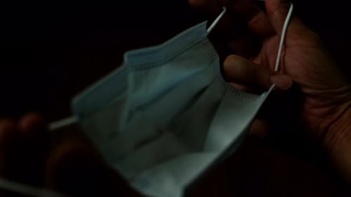 Hands Holding Surgical Mask in Close Up