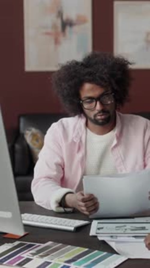Vertical of Biracial Male Interior Designer Looking at Drawing Plans