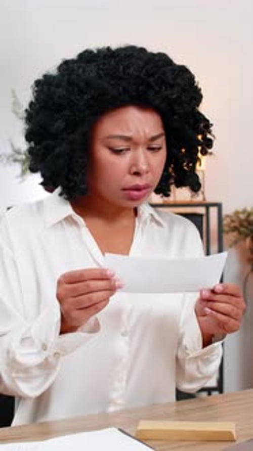 Woman Receiving Bad News in Letter at Desk