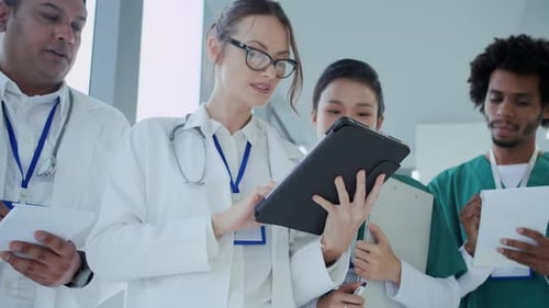 Four Multiethnic Doctors Discussing Plan of Treatment at Clinic
