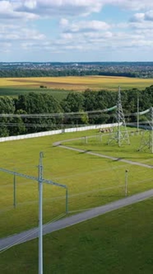 Electric transmission towers on a green field. Power lines supply with wires.