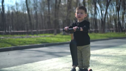 A Young Child is Joyfully Riding a Colorful Scooter in the Beautiful Park on a Sunny Day