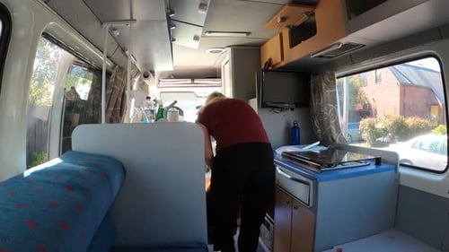 Young Adult Man in Campervan Opens Cabinets