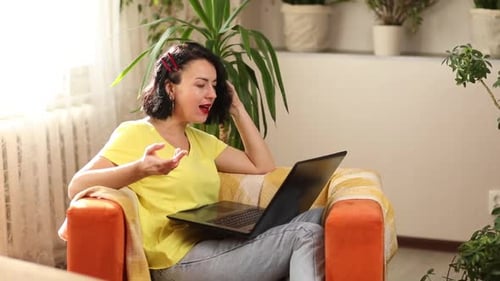 Woman Video Calling on Laptop From Cozy Chair