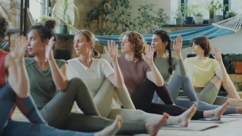 Femmes pratiquant une pose tordue assise pendant une leçon de yoga