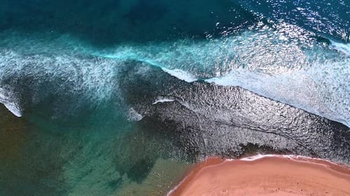 Turquoise waterscape with white foamy waves rolling to the shore.