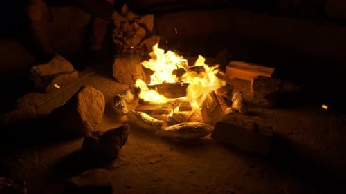 Nighttime Campfire Flames Surrounded by Rocks