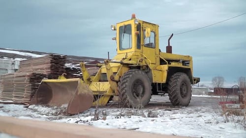 Yellow Bulldozer Sitting on Snow in Rural Area