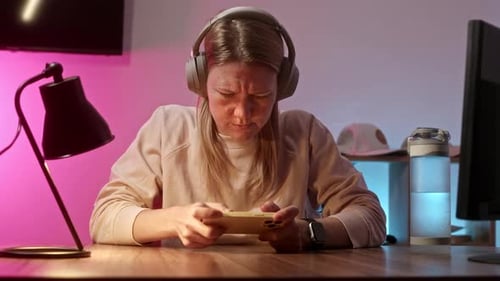 Woman Fails at Phone Game Indoors at Desk