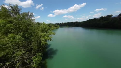 Aerial view of a lake near a village and a mountain road