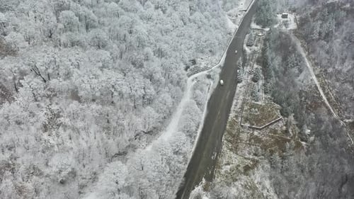 Aerial footage road near snowy forest. Trail in snowy forest.