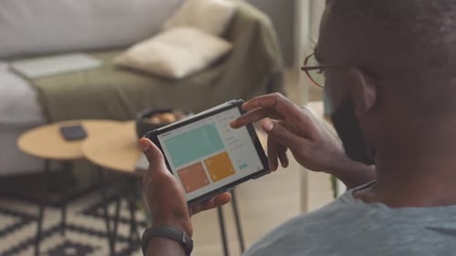 Man Browsing on Tablet at Home